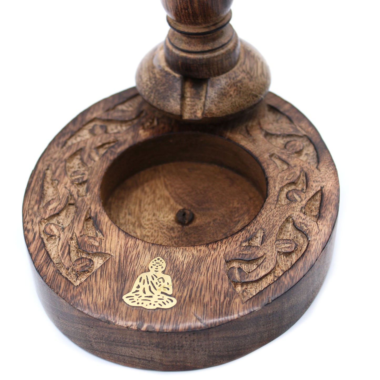 A wooden stand features intricate carvings around its base and a circular indentation. A small gold Buddha symbol is embedded on the surface, enhancing its spiritual aesthetic.