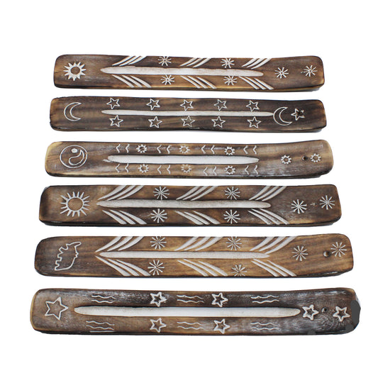 Wooden incense holders feature engraved celestial designs like stars, moons, and suns. They are arranged in a horizontal layout on a plain background, showcasing a rustic aesthetic.