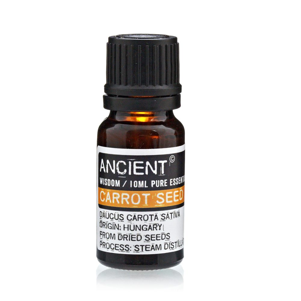 A brown glass bottle with a black lid sits against a white background. The label says "ANCIENT WISDOM/10ML PURE ESSENT CARROT SEED DAUCUS CAROTA SATIVA ORIGIN: HUNGARY FROM DRIED SEEDS PROCESS: STEAM DISTILL"