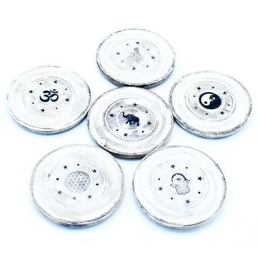 Decorative wooden coasters display symbols like Om, elephant, yin-yang, Buddha, flower of life, and hamsa hand, each surrounded by stars, against a white background.