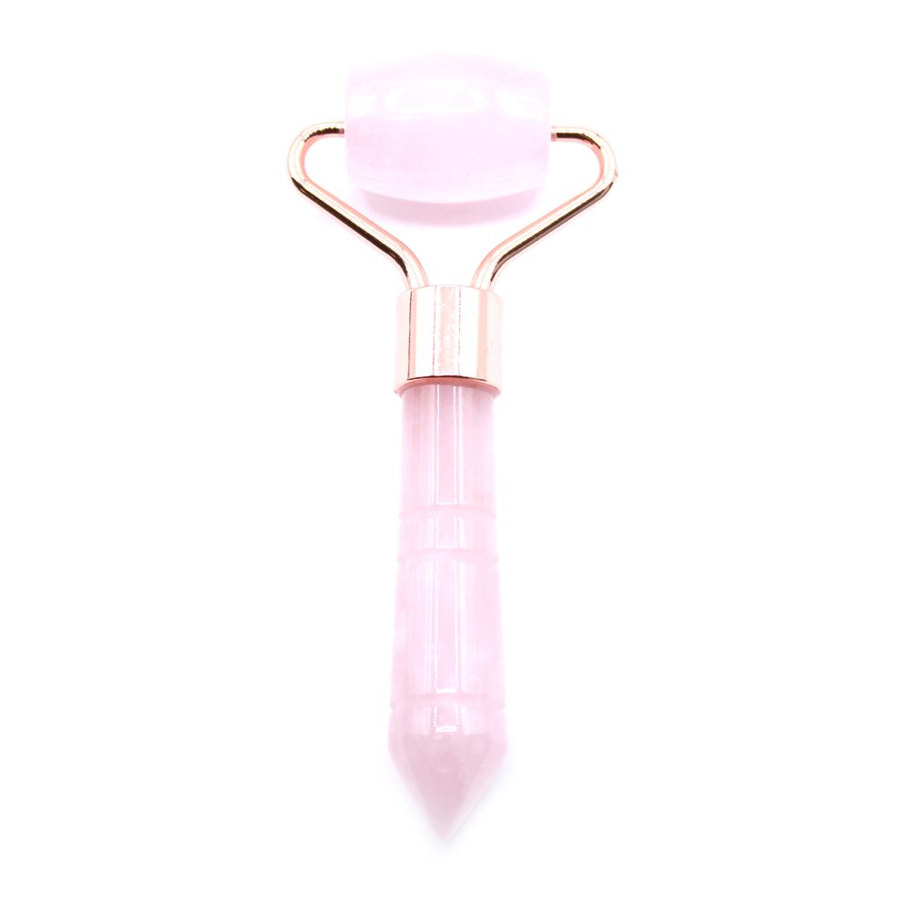 A rose quartz facial roller, featuring a pink roller and a pointed handle with gold-colored metal fixtures, sits upright against a stark white background.