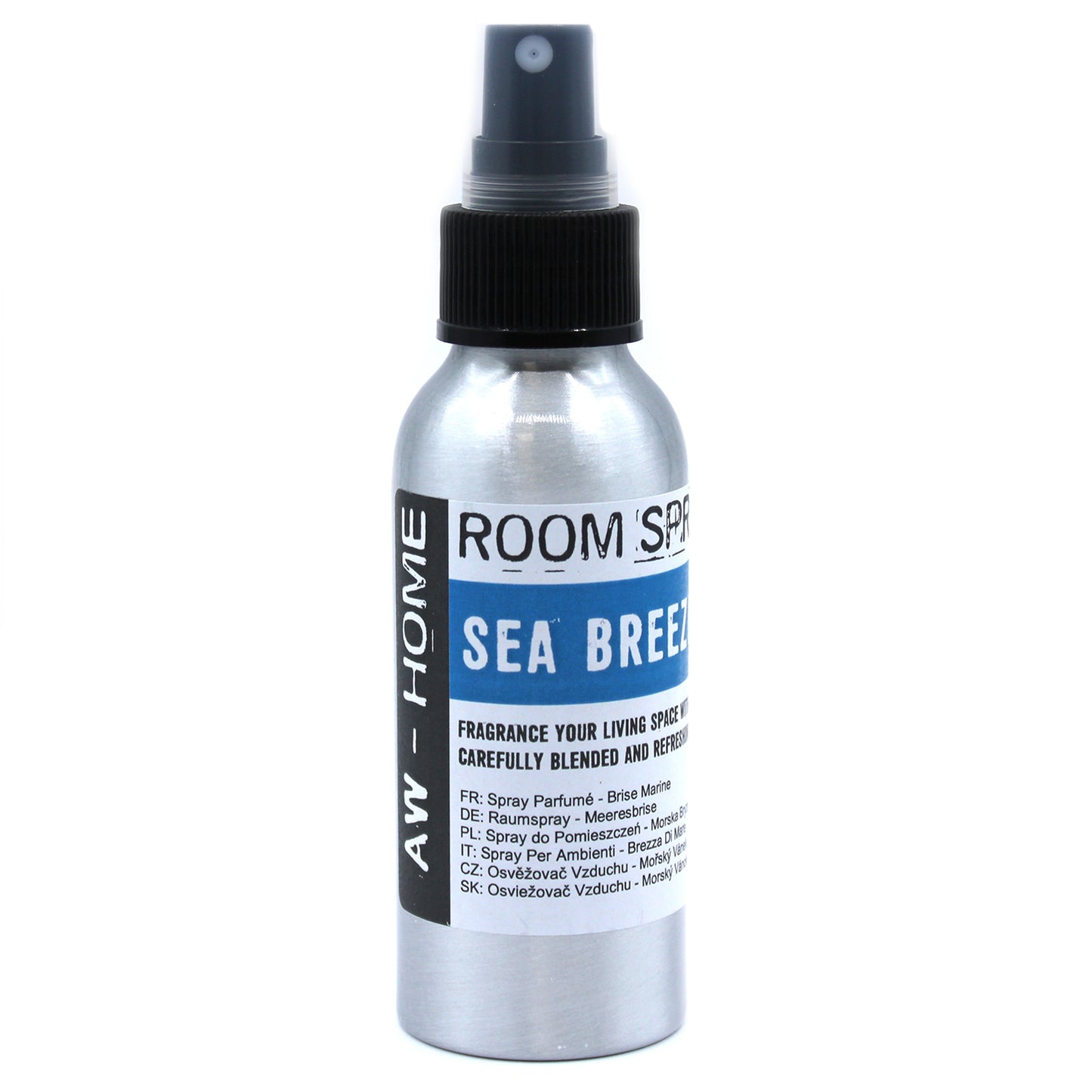 A silver spray bottle, dispensing room fragrance, sits against a white background. The label reads: "ROOM SPRAY," "SEA BREEZE," and provides fragrance names in several languages.
