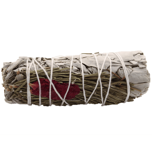 A sage bundle, wrapped with white string and a red flower petal, sits horizontally against a solid green background.
