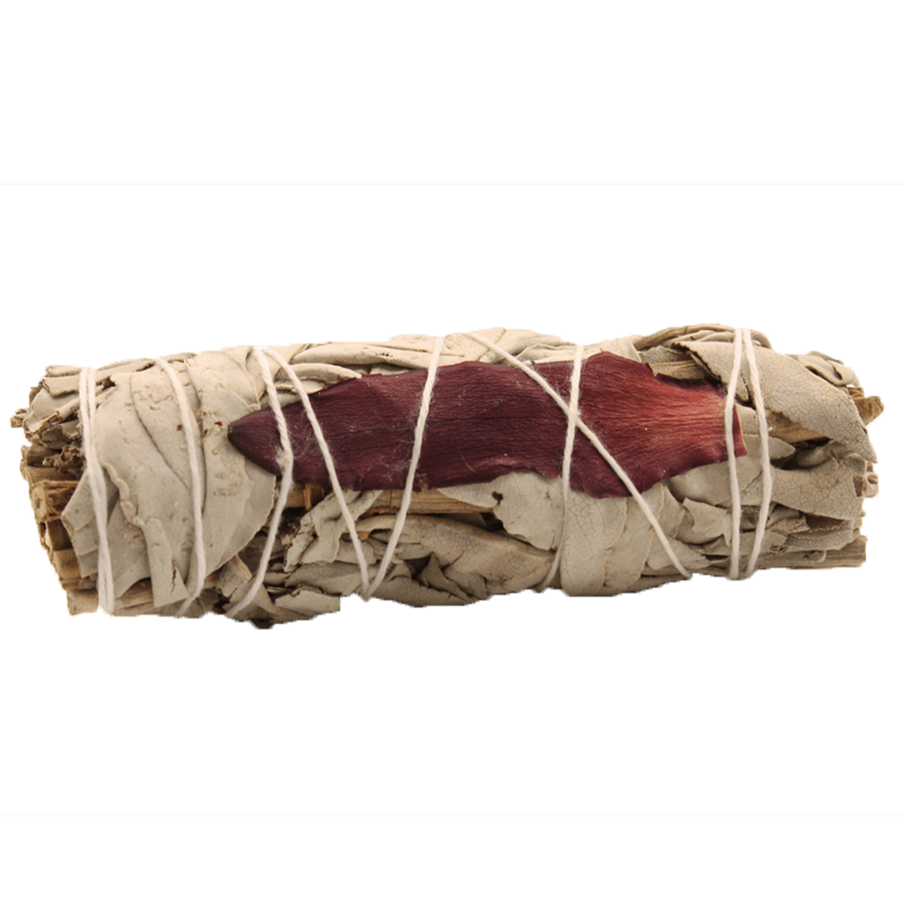 A bundle of pale dried sage leaves and red flower petals sits wrapped tightly with white twine, against a dark green background.
