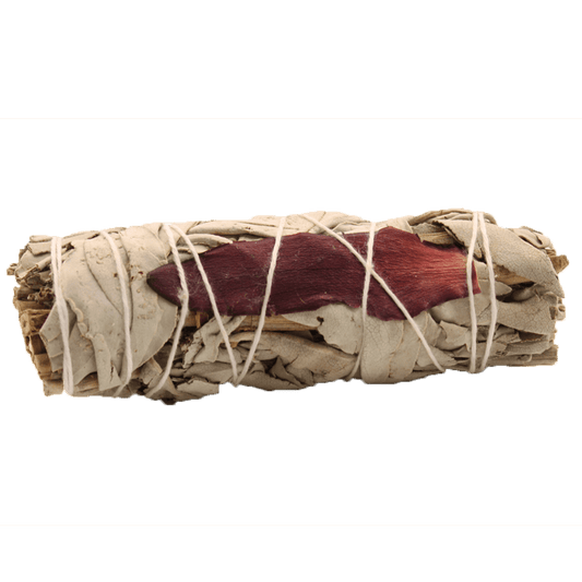 A bundle of pale dried sage leaves and red flower petals sits wrapped tightly with white twine, against a dark green background.