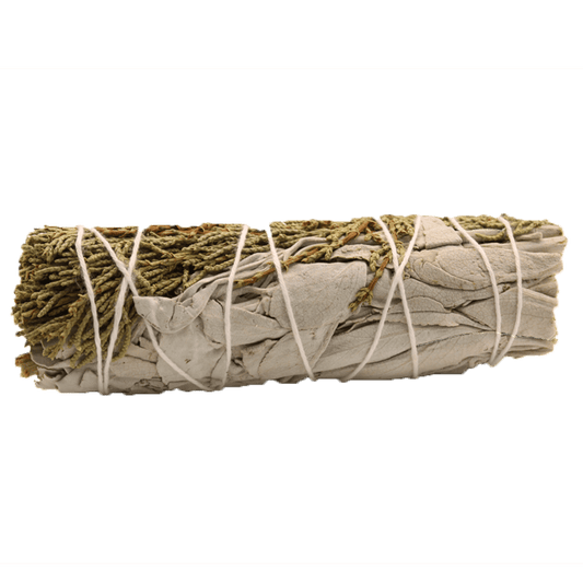 A bundle of dried sage leaves and juniper needles, wrapped in white string, sits centered against a solid, muted green background.