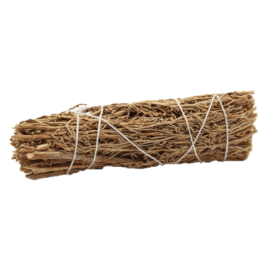 A bundle of dried sticks and leaves is bound with white string. The bundle rests horizontally against a solid green background.