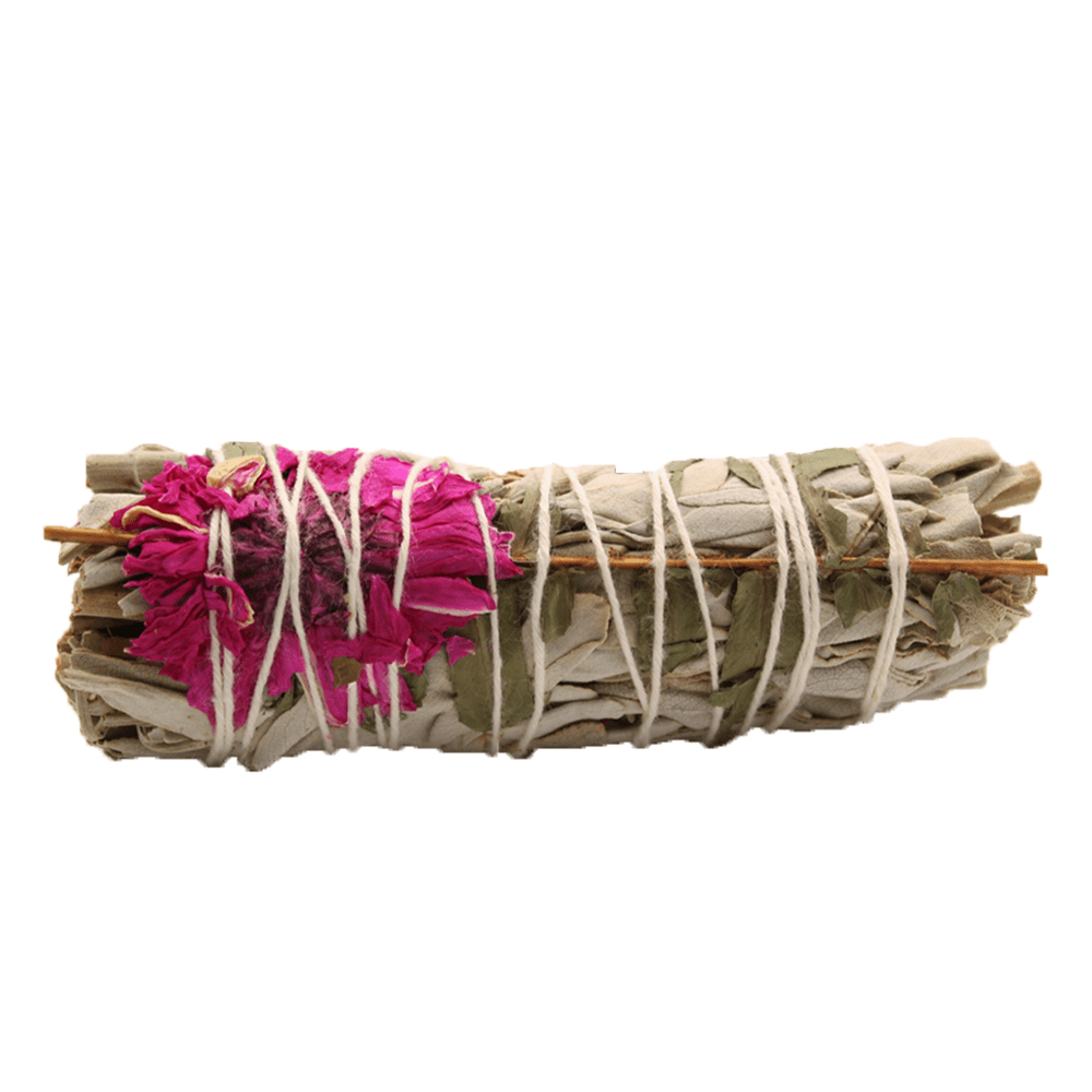 A sage bundle is wrapped with string and decorated with a pink flower. Sticks run along the sides in a blank, white space.
