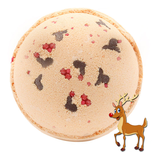 A round, textured beige macaron is decorated with black and red speckles, resembling reindeer, against a white background. A cartoon reindeer with a red nose stands at the bottom right.