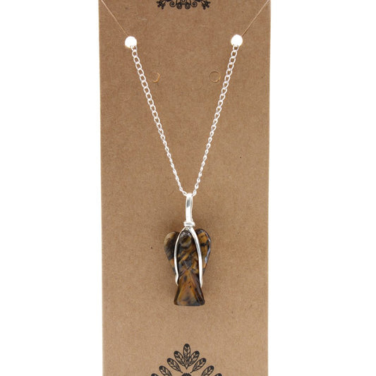 A tiger's eye crystal angel pendant hangs from a silver chain against a brown cardboard display with ornate embellishments.