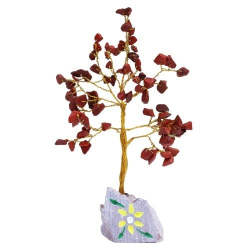 A wire tree trunk rises from a small, grey stone base with a painted yellow flower design, with branches laden with red gemstone "leaves" against a white background.