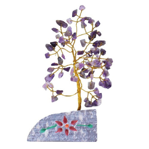 A wire tree blooms with small, purple stone leaves, arising from a gray stone base adorned with a painted red flower and green leaves, against a white background.