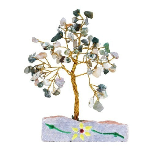 A tree made of gold wire and green and white polished rocks is standing atop a rectangular stone base, which is decorated with a flower. The background is white.