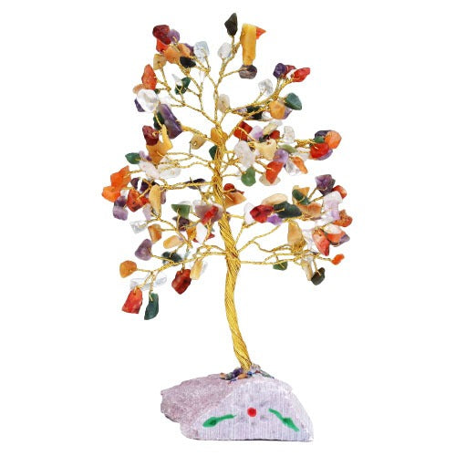 A decorative tree with a gold wire trunk displays colorful gemstone leaves, rooted in a light pink stone base decorated with green and red paint in a simple floral pattern.