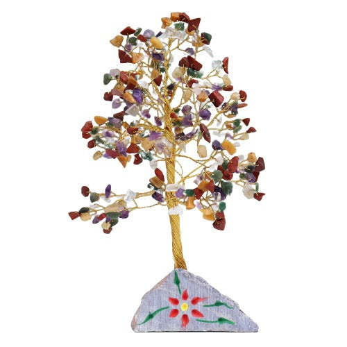 A decorative tree made from gold wire and colorful stones stands on a gray, flower-painted stone base, set against a white backdrop.