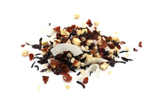 A small pile of loosely scattered dried fruit and coconut shreds, featuring various shapes and colors, rests on a white background, displaying a mix of textures and hues.