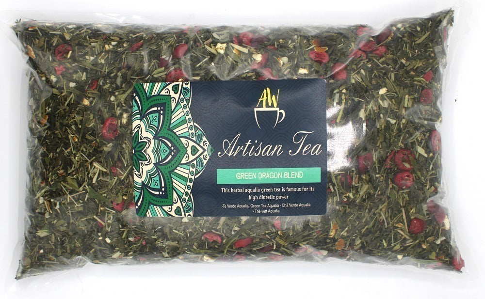 Clear plastic bag filled with loose tea leaves mixed with red berries. Label reads: "AW Artisan Tea, GREEN DRAGON BLEND. This herbal aqualia green tea is famous for its high diuretic power. Té Verde Aqualia – Green Tea Aqualia – Chà Verde Aqualia – Thé vert Aqualia." The label features a green and teal mandala design.