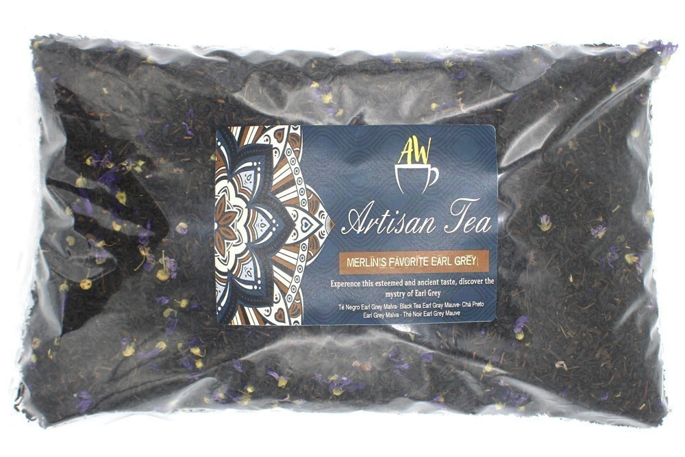 A sealed plastic bag contains loose leaf tea with small flowers, labeled "Artisan Tea." The label reads: "MERLIN'S FAVORITE EARL GREY. Experience this esteemed and ancient taste, discover the mystery of Earl Grey."