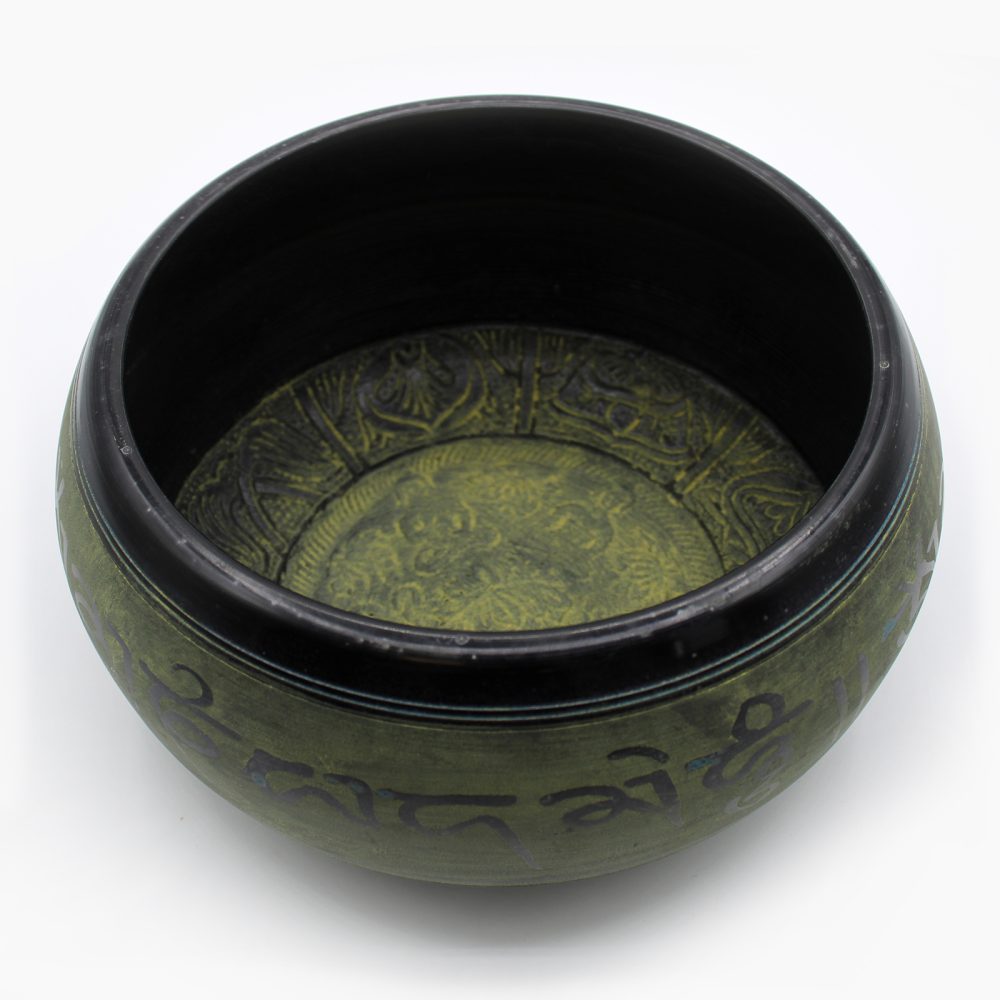 Bowl with intricate, engraved designs on inner and outer surfaces, featuring script around the exterior. It sits on a plain, white backdrop, emphasizing its detailed craftsmanship.