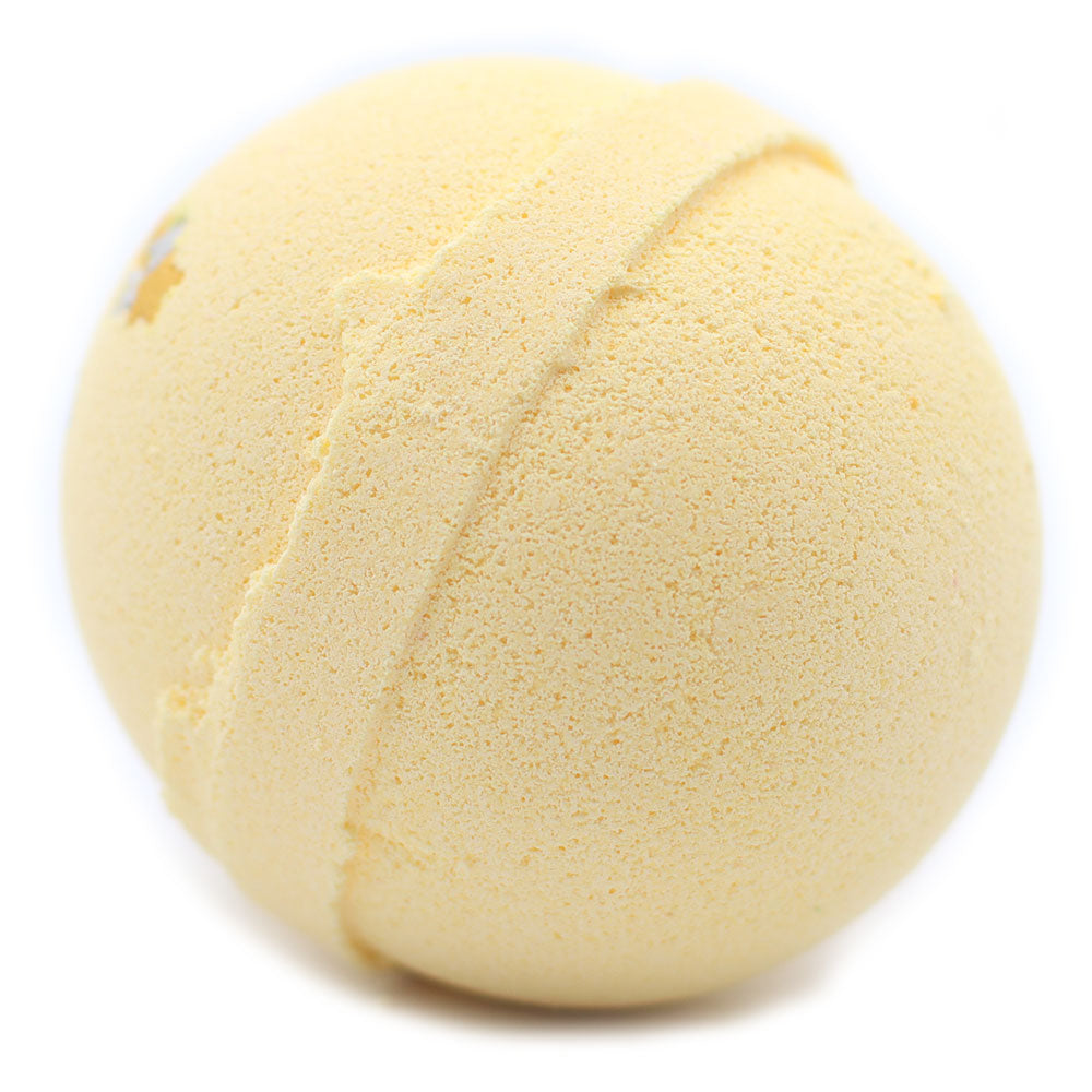 Yellow, textured sphere resting on a plain white surface. The sphere features a prominent seam running around its circumference, indicative of a bath bomb's design.