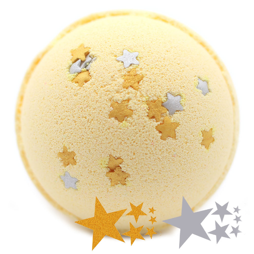 A yellow bath bomb adorned with small gold and silver star shapes sits against a white background, surrounded by digital star graphics in gold and silver hues.