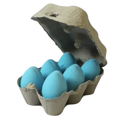 A cardboard egg carton holds six bright blue eggs, with the lid open, placed on a plain white background.