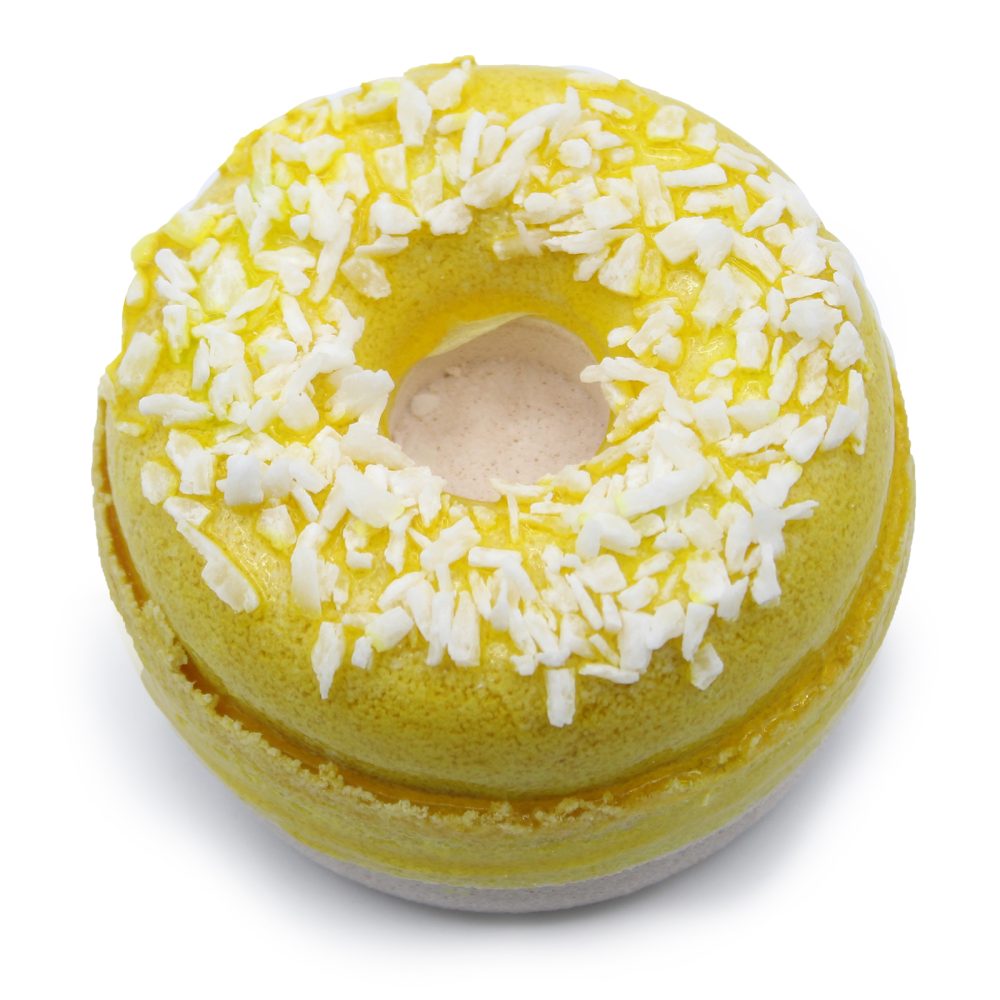 Yellow macaron shaped like a donut, topped with white coconut flakes, resting on a white surface.