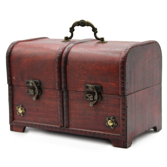 A small, vintage-style wooden chest with a curved brass handle sits on a plain surface. It features ornate metal latches and decorative edges, conveying an antique appearance.