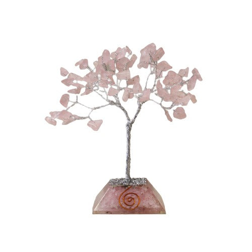 A tree made of twisted silver wire supports pink stone “leaves,” rising from a faceted pink stone base with a copper spiral design, all isolated against a white background.