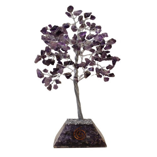 Amethyst gemstones form the leaves of a crystal tree with silver wire branches, rooted in a purple, pyramid-shaped gemstone base with copper wire design, against a white backdrop.