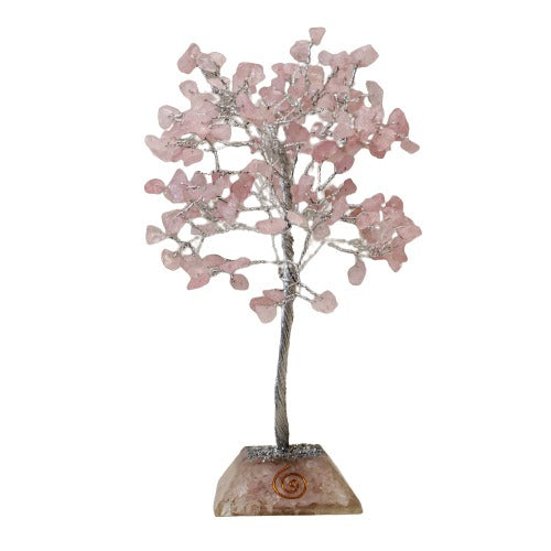 A crystal tree with a metallic trunk and branches stands on a rough, square stone base, adorned with pink crystals as leaves, against a white background.