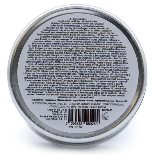 Round metal tin of body butter sits on a white surface; Transcription: DE: Körperbutter. Leicht duftende Butter ist ideal für den täglichen Gebrauch nach dem Baden oder Duschen sowie für die Körpermassage. Gebrauchsanweisung: Reinigen Sie die Haut vor dem Auftragen in einer warmen bis heißen Dusche oder einem Bad, um die Poren zu öffnen. Massieren Sie sanft eine kleine Menge unserer Butter in Ihre Haut. Lassen Sie die Butter einige Minuten einwirken, bevor Sie sich anziehen. FR: Beurre Corporel. Légèrement
