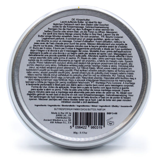 Round tin of body butter resting on white background; label text: DE: Körperbutter. Leicht duftende Butter ist ideal für den täglichen Gebrauch nach dem Baden oder Duschen sowie für die Körpermassage. Gebrauchsanweisung: Reinigen Sie die Haut vor dem Auftragen in einer warmen bis heißen Dusche oder einem Bad, um die Poren zu öffnen. Massieren Sie sanft eine kleine Menge unserer Butter in Ihre Haut. Lassen Sie die Butter einige Minuten einwirken, bevor Sie sich anziehen. FR: Beurre Corporel. Légèrement parfu