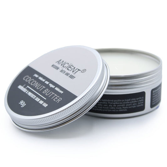 Small metal tin of coconut butter sits open on a white surface with lid leaning against the base; text reads: ANCIENT® HOME BATH AND BODY pure natural and vegan skincare COCONUT BUTTER MOISTURISES & PROTECTS SKIN AND HAIR 90g