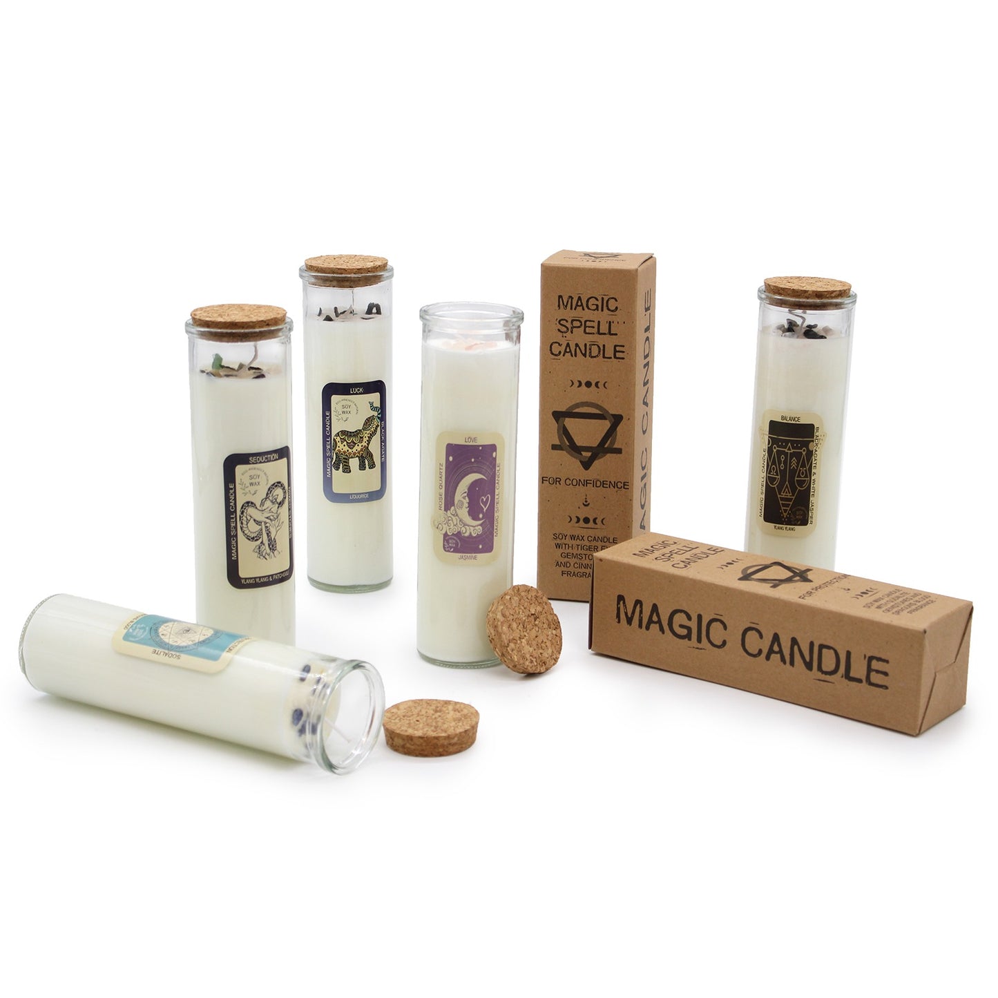 Candles standing and one lying with cork lids beside cardboard boxes on a white surface: labels read "SEDUCTION", "LUCK", "LOVE", "BALANCE" and boxes read "MAGIC SPELL CANDLE", "FOR CONFIDENCE", "MAGIC CANDLE".