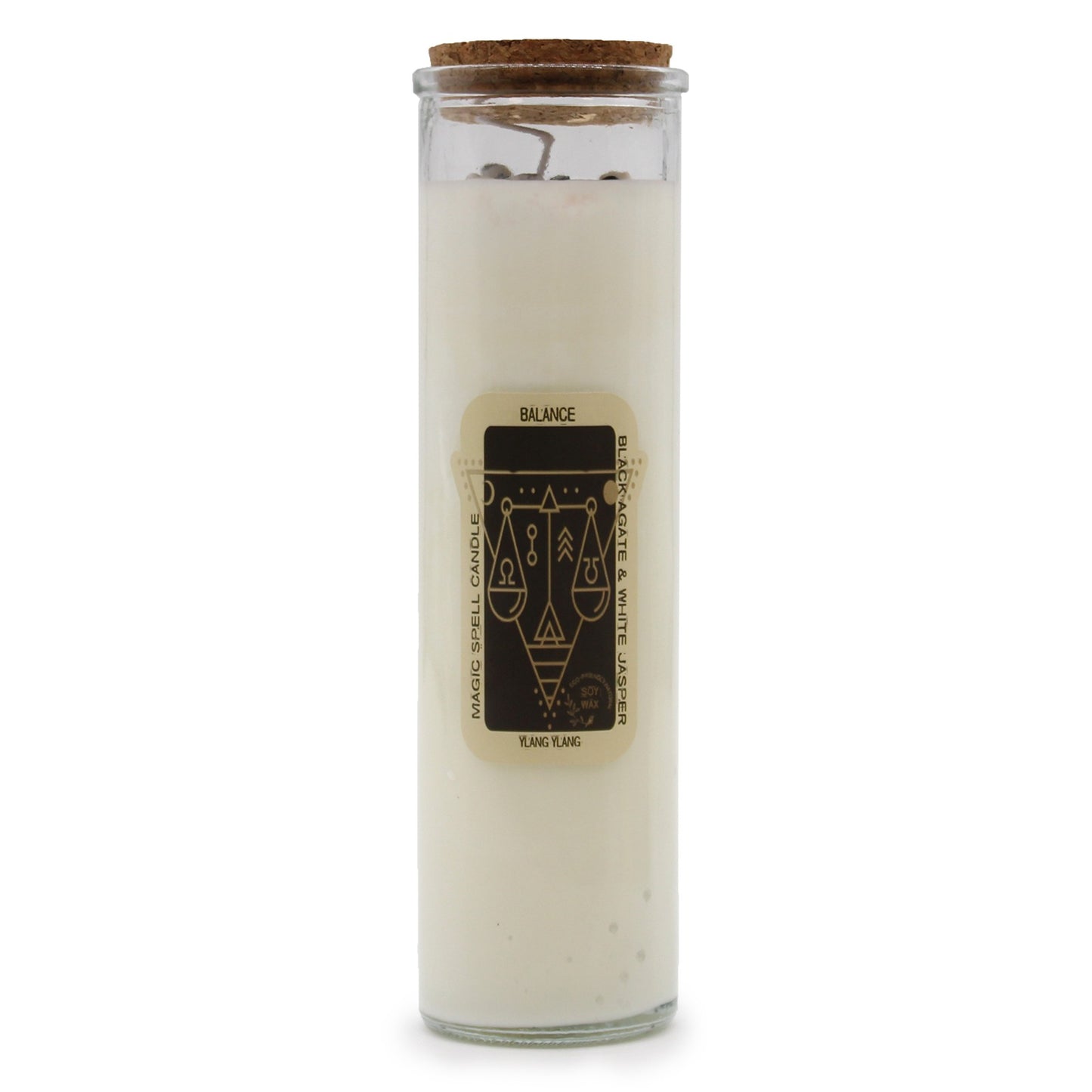 A glass-encased candle, topped with a cork lid, sits on a white surface. The candle has a cream wax filling and a label that reads "BALANCE. MAGIC SPELL CANDLE, BLACK AGATE & WHITE JASPER, YLANG YLANG".