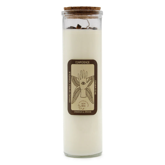 Tall glass jar candle sits sealed with a cork, white soy wax topped by small stones around a wick on a white background; label reads: CONFIDENCE; MAGIC SPELL CANDLE; TIGER EYE; ECO-FRIENDLY NATURAL SOY WAX; CINNAMON & ORANGE.