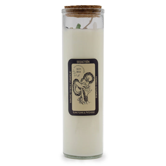 Tall glass jar candle stands upright containing white soy wax with cork lid against a white background; label reads: SEDUCTION, ECO-FRIENDLY NATURAL, SOY WAX, MAGIC SPELL CANDLE, MIXED STONES, YLANG YLANG & PATCHOULI.