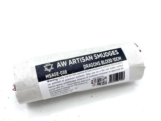 A rolled tube of Dragons Blood artisan smudges rests on a white surface; the label indicates usage instructions and warnings. MSAGE-038.