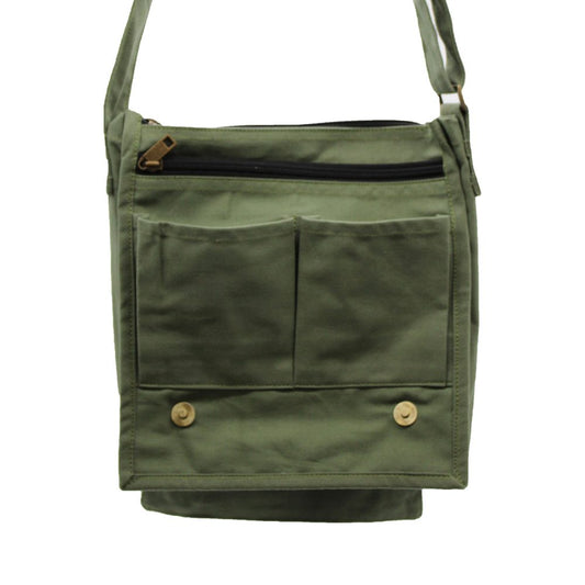 An olive green canvas bag is displayed with two pockets on the front and a zippered pocket at the top, hanging with a strap over a white surface.