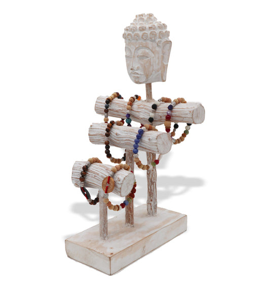 A white wooden jewelry stand displays multiple beaded necklaces. The stand has a Buddha head at the top and three horizontal rods for hanging the necklaces, set against a white background.