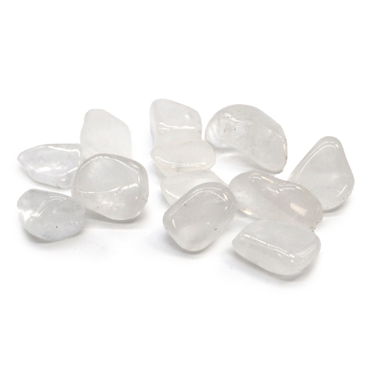 White tumbled stones are scattered, clustered centrally on a solid white background, with soft shadows underneath the stones.