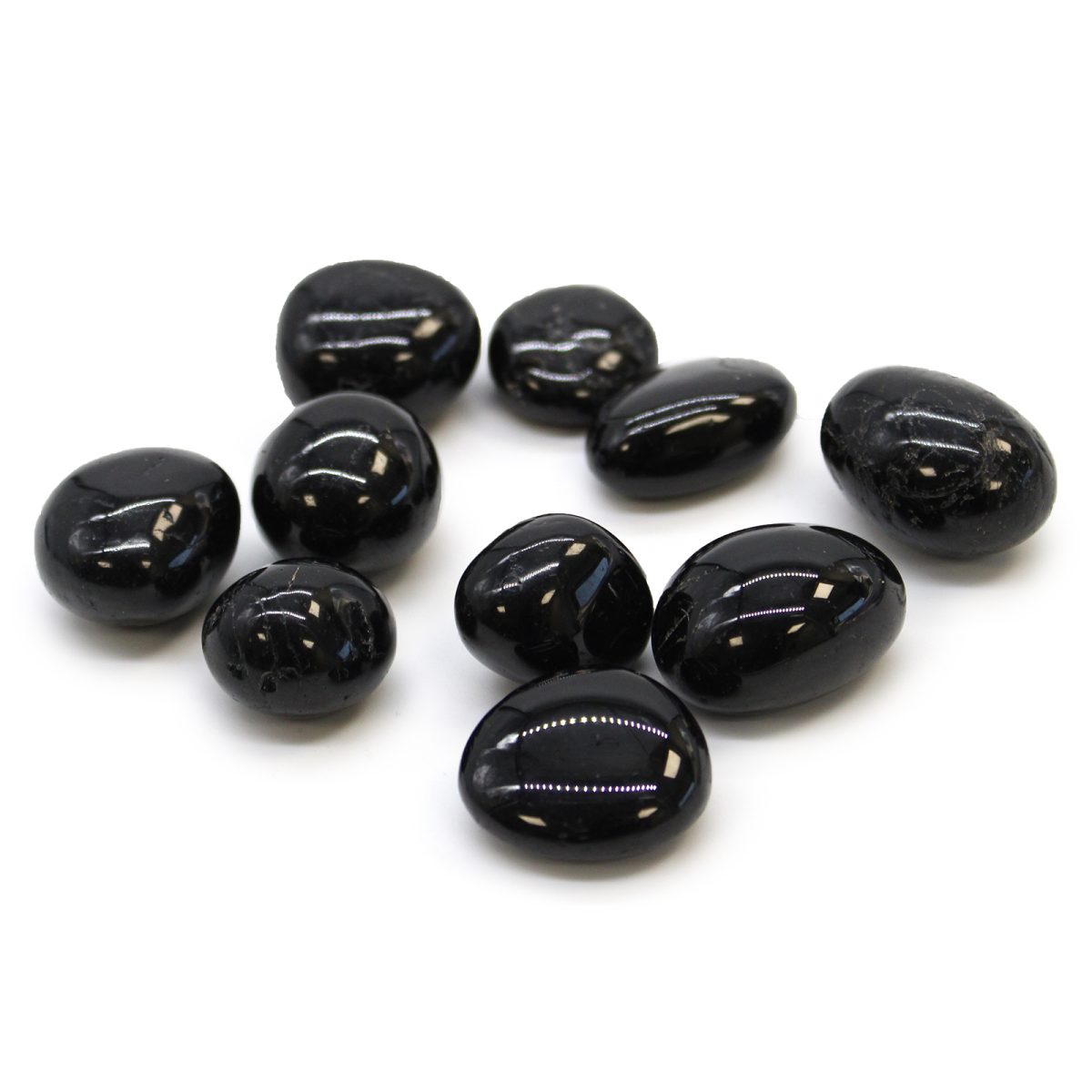 A scattering of ten shiny, black, tumbled stones rests on a clean, white surface.