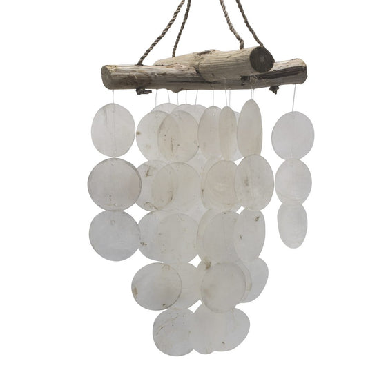 A driftwood-hung mobile of numerous translucent, circular shell pieces gently chimes, hanging against a white background.