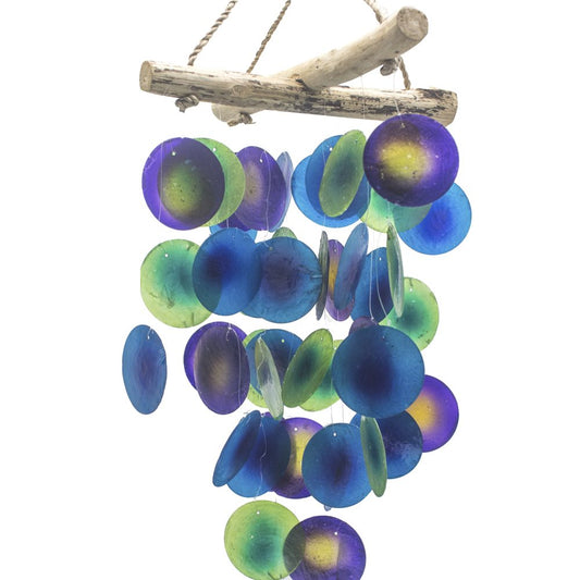 A driftwood-hung mobile, comprised of numerous circular, multicolored shell-like discs, gently chimes.