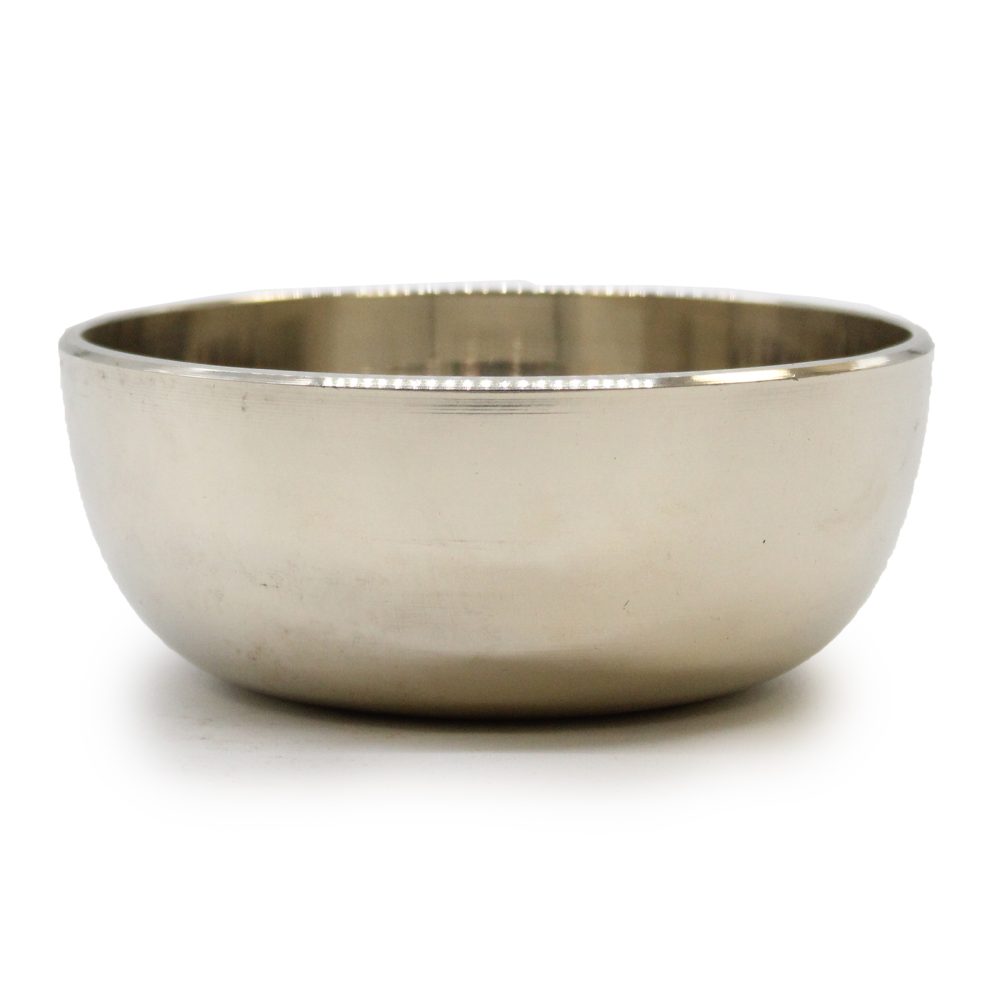 A shiny, stainless steel bowl sits on a plain white surface, reflecting light subtly. Its smooth, rounded shape and polished exterior give it a clean, modern look.