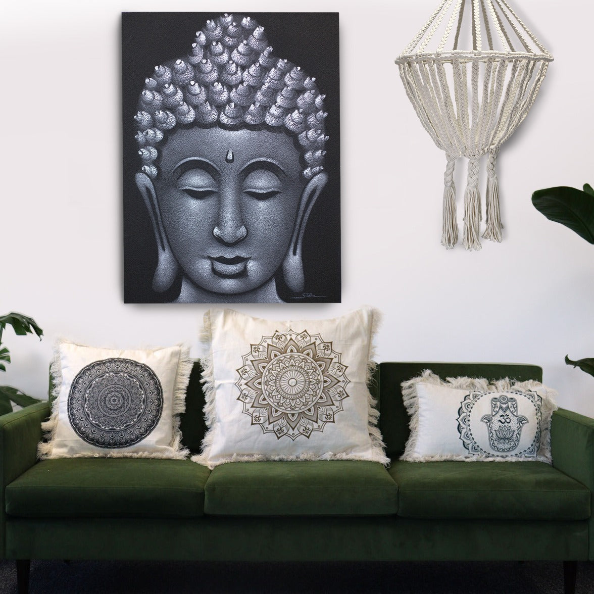 A serene Buddha painting hangs above a green couch adorned with mandala-patterned throw pillows.