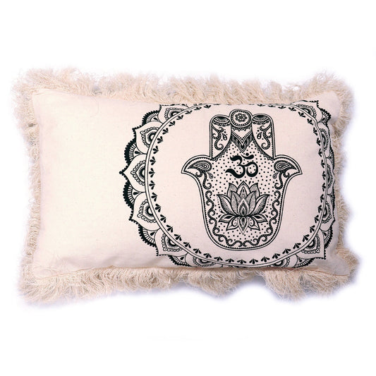 A beige rectangular pillow, rests on a white background. It features a black and white Hamsa hand design within a mandala, accented by a fringe border.