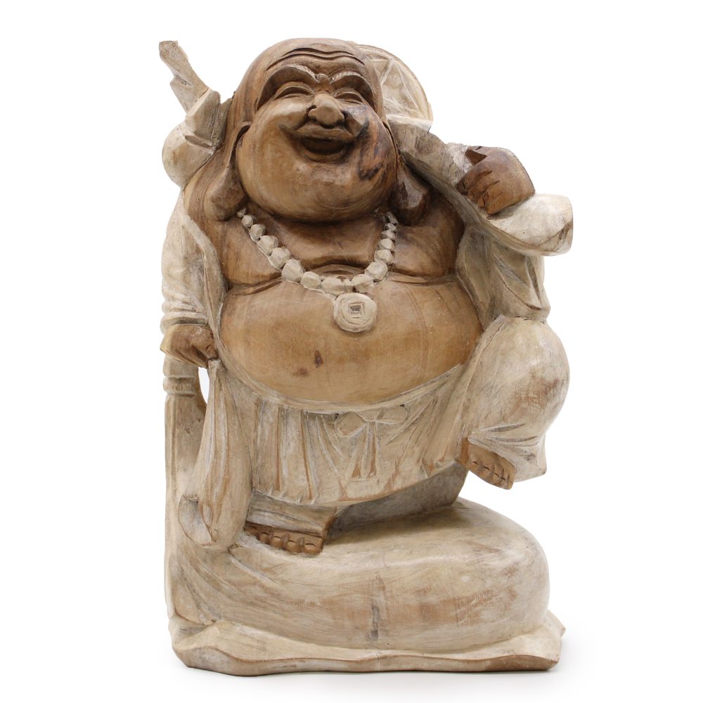 A wooden statue of a laughing Buddha, wearing a beaded necklace, holding a sack over his shoulder and standing on one leg, displayed against a plain white background.