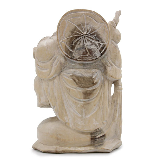 A carved wooden statue depicts a robed figure holding a disc with an engraved star pattern. The statue displays intricate drapery textures and stands alone without a visible background.